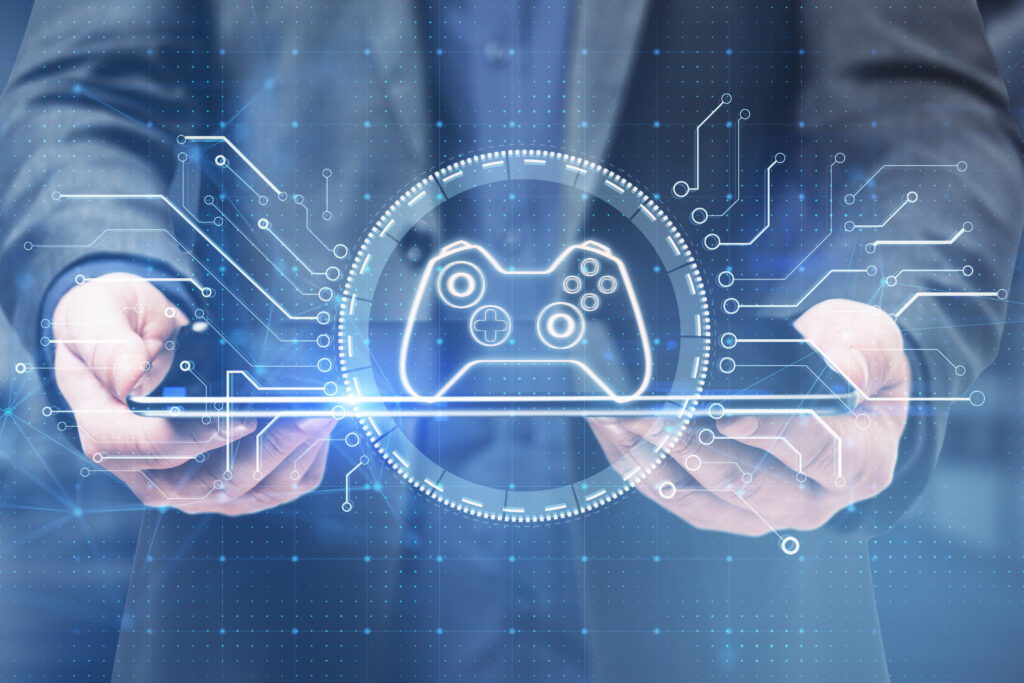 close-up-businessman-hand-holding-tablet-creative-joystick-gamepad-hologram-blurry-office-interior-background-esport-gaming-fun-concept-double-exposure
