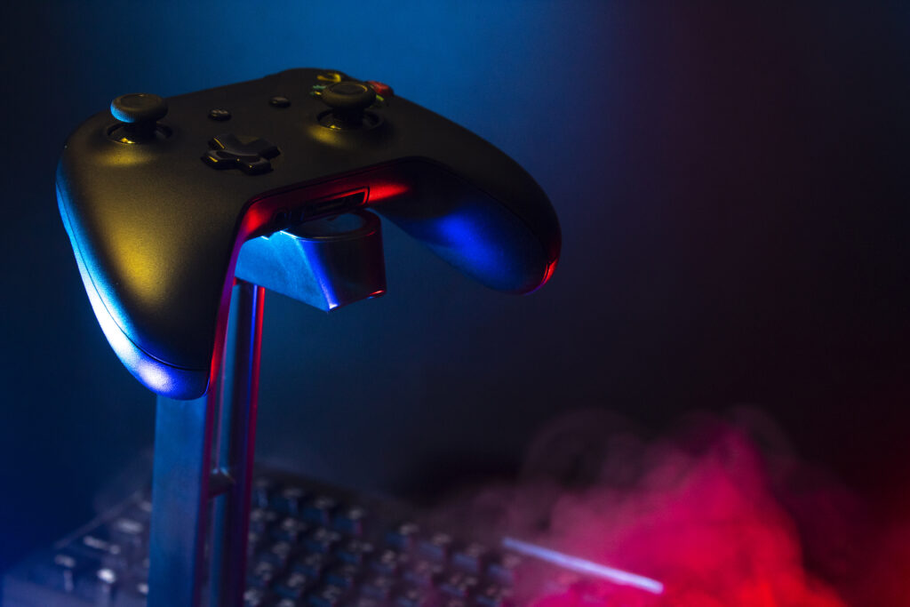 gamer-devices-playing-game-by-joystick-with-computer-headphone-mouse-neon-glow-gaming-esports-challenge-streaming-online-tournament-concept