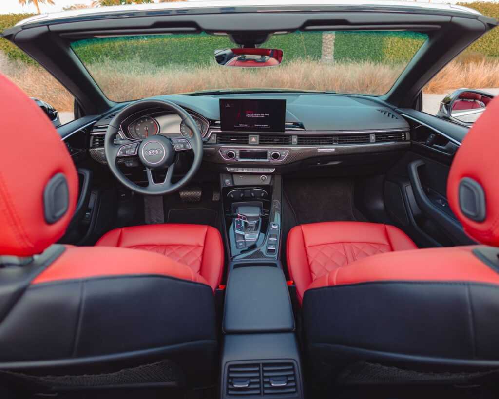 Explore the luxury and design of an Audi convertible interior with vibrant red seats in Dubai.